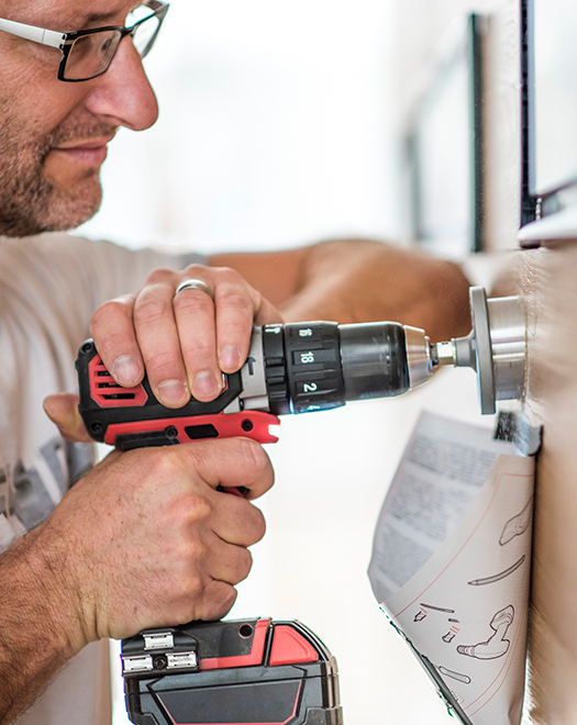 man fixing a door with a drill Installation Services